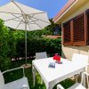 Tavolo bianco con ombrellone nel giardino.