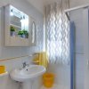 Bagno luminoso con doccia e lavandino.